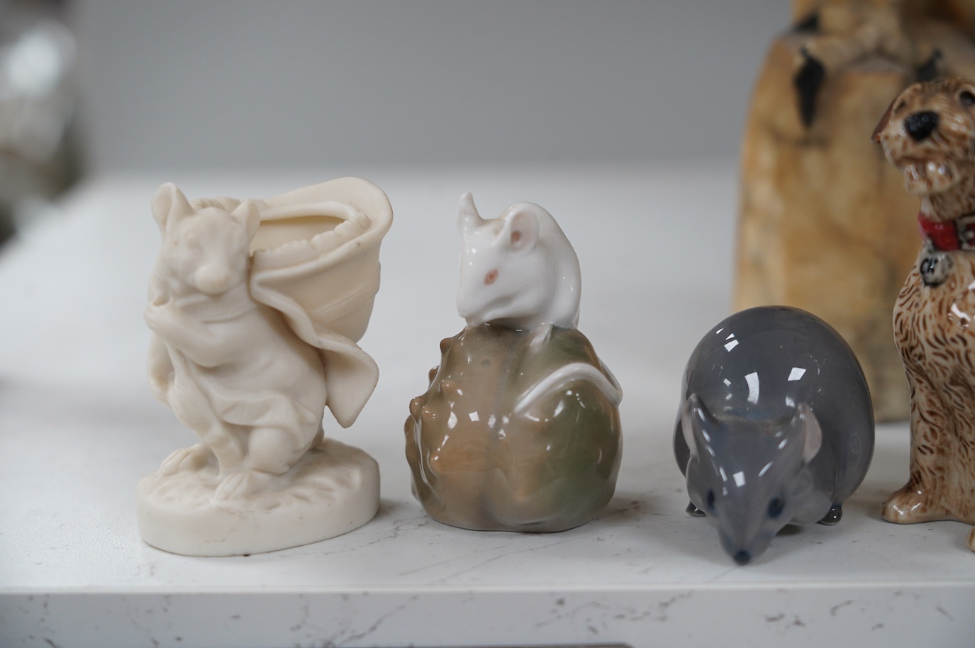 A carved alabaster parrot, a stone carving of two mice, two Royal Copenhagen mice, a mouse spill vase, a pair of dog pepperettes and a hare ornament, tallest 26cm high (8). Condition - small chip to ear of white Copenhag